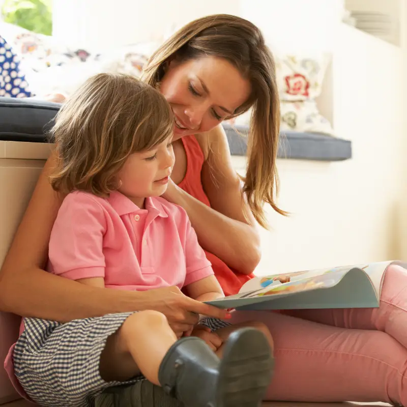Mother reading a picture book to her son. How Children learn to read