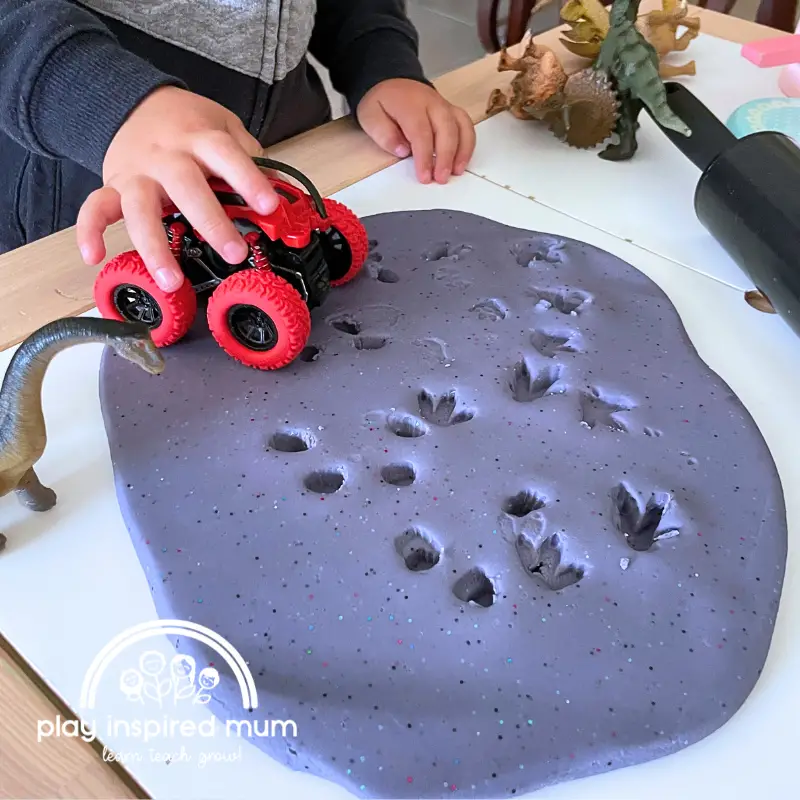 dinosaur footprints in playdough and monster truck tracks