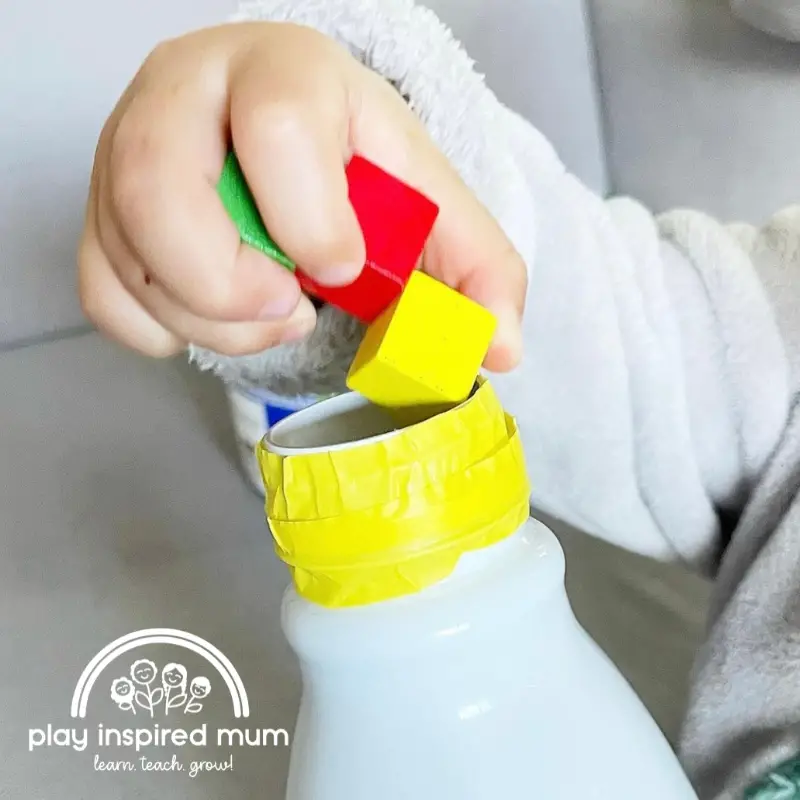 Posting activity toddler hand with wooden blocks