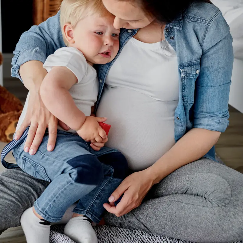Can toddlers sense pregnancy. Mum hugging her upset toddler 